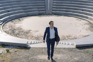 Erwachsener Geschäftsmann in einem Amphitheater auf einer stillgelegten Bergwerkshalde - JOSEF00396