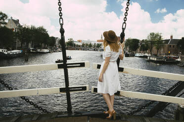 Frau auf Brücke mit Blick auf die Stadt - CAVF79825