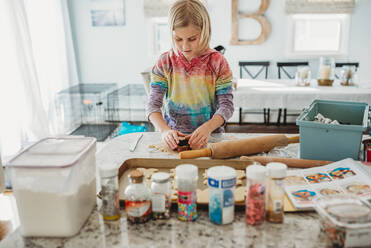 Young girl cutting out cookies in the kitchen - CAVF79849