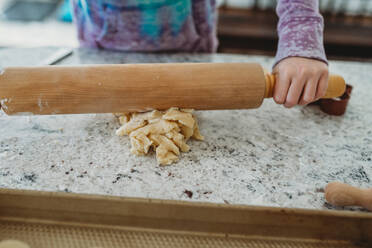 Girl rolling out dough in the kitchen with a rolling pin - CAVF79850