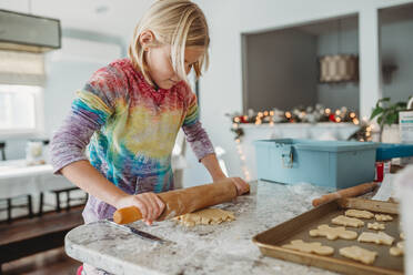Girl rolling out cookie dough side view - CAVF79855