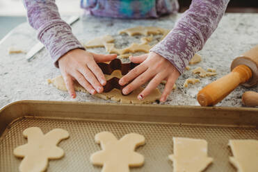 Young Girl hands using cookie cutter on cookie dough - CAVF79857