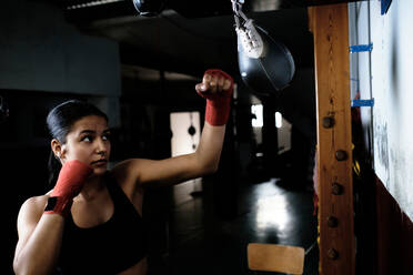 Junge Frau übt im Fitnessstudio Boxen - CAVF79861