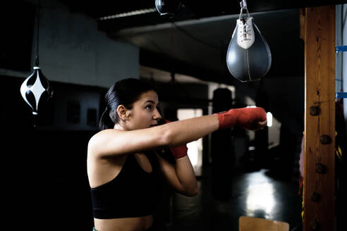 Junge Frau übt im Fitnessstudio Boxen - CAVF79862