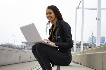 Frau benutzt ihren weißen Laptop. - CAVF79989