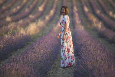 Frau, die das Lavendelfeld beobachtet - CAVF80045