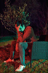 Trauriger Mann sitzt nachts allein auf einer Gartenbank - ZEDF03317
