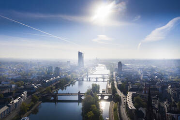 Deutschland, Hessen, Frankfurt, Blick aus dem Hubschrauber auf die Sonne, die über den Main und die umliegenden Gebäude scheint - AMF08020