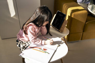 Girl doing homework in the living room - ERRF03519