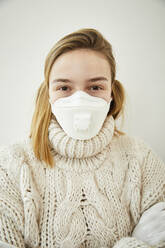 Portrait of blond woman wearing FFP2 mask at home - FSF01034