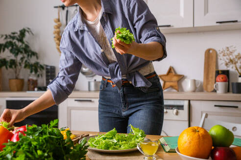 Junge und schöne Hausfrau Frau Kochen in einer weißen Küche - CAVF80154