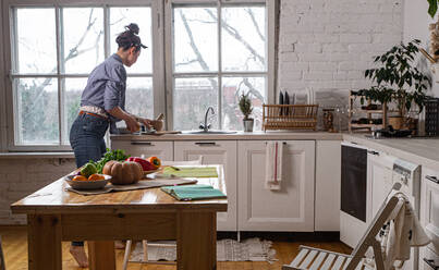 Young and beautiful housewife woman cooking in a white kitchen - CAVF80163