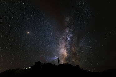 Silhouette of a mountaineer looking at the Milky Way - CAVF80218