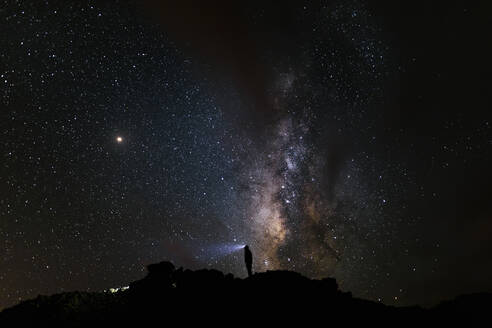 Silhouette eines Bergsteigers mit Blick auf die Milchstraße - CAVF80218