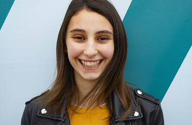 Young woman smiling on a blue background. - CAVF80338