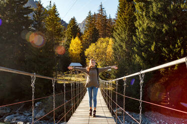 Mädchen Reisende auf Hängebrücke in den Hintergrund des Waldes - CAVF80357