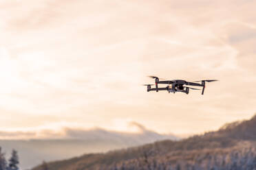 Drohne fliegt in der Dämmerung bei Sonnenuntergang. - CAVF80427