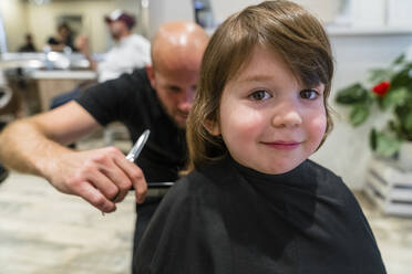 Portrait of smiling little girl getting haircut - MGIF00904