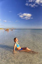 Mlata, Teenage girl wearing bikini, standing in the sea at Comino beach  stock photo