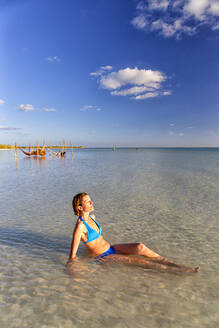 Ältere Frau beim Sonnenbaden am Strand der Insel Holbox, Cancun, Mexiko - DSGF02014