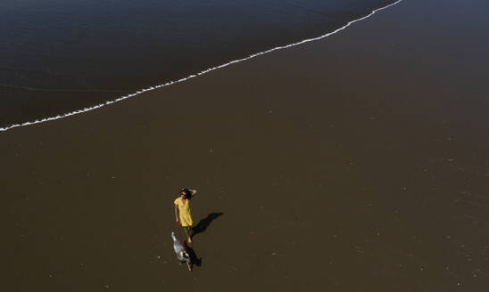 Junge Frau geht mit ihrem Hund am Strand spazieren, Costa Rica - AMUF00092