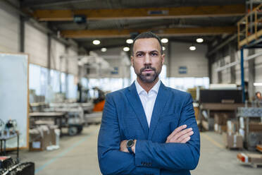 Portrait of a confident businessman in a factory - DIGF09913