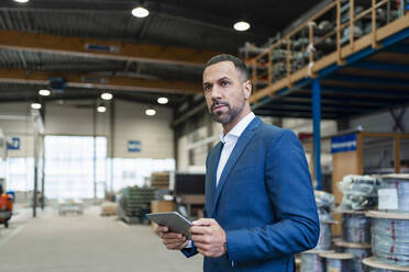 Businessman using tablet in a factory - DIGF09915