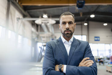 Portrait of a confident businessman in a factory - DIGF09923