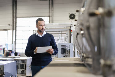 Businessman using tablet in a factory - DIGF09977