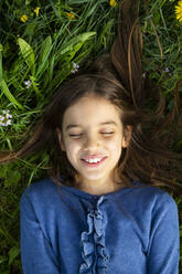 Porträt eines Mädchens mit geschlossenen Augen, das sich auf einer Wiese im Frühling entspannt - LVF08850
