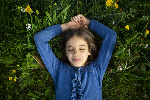 Porträt eines Mädchens mit geschlossenen Augen, das sich auf einer Wiese im Frühling entspannt - LVF08851