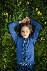 Porträt eines Mädchens mit geschlossenen Augen, das sich auf einer Wiese im Frühling entspannt - LVF08852