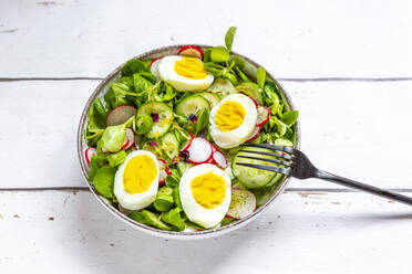 Bowl of vegetarian salad with boiled eggs, radishes, cucumbers, corn salad and edible flowers - SARF04551
