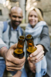 Ehepaar stößt mit Bierflaschen an, Barcelona, Spanien - XLGF00102