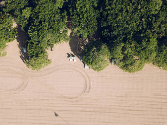 Indonesien, Bali, Nusa Dua, Luftaufnahme von grünen Bäumen, die sich entlang des Sandstrandes erstrecken - KNTF04522