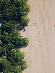 Indonesien, Bali, Nusa Dua, Luftaufnahme von grünen Bäumen, die sich entlang des Sandstrandes erstrecken - KNTF04523