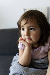 Porträt eines Mädchens, das zu Hause auf der Couch sitzt - VABF02822