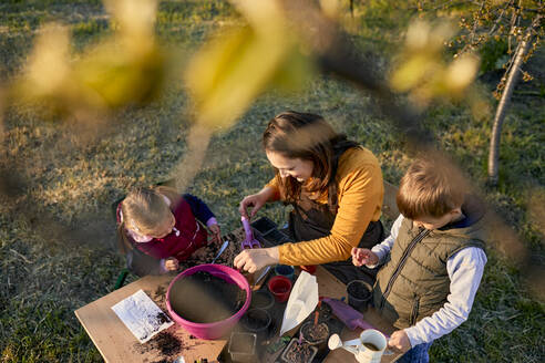 Mother with two kids gardening - ZEDF03332