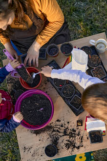 Mother with two kids gardening - ZEDF03336