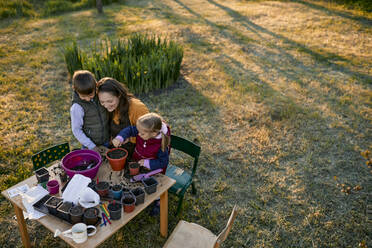 Mutter mit zwei Kindern bei der Gartenarbeit - ZEDF03338