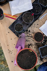 Flowerpots with soil and gardening tools on table - ZEDF03342