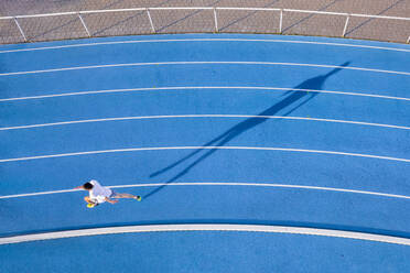 Aerial view of runner on blue tartan track - STSF02521