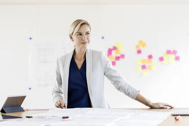 Blonde Geschäftsfrau im Konferenzraum mit Haftnotizen am Whiteboard - PESF01964