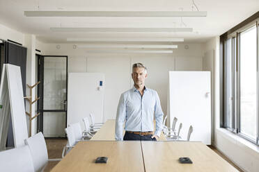 Portrait of confident mature businessman in conference room - PESF01992