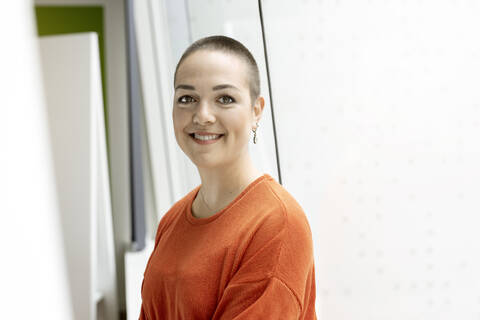 Portrait of smiling young woman at the window in office stock photo