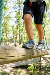 Junge läuft auf Baumstamm, Hochseilgarten im Wald - MGIF00915