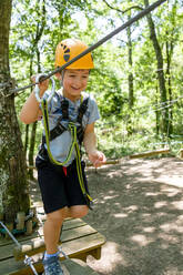 Boy on a high rope course in forest - MGIF00918