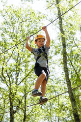 Junge auf einem Hochseilgarten im Wald - MGIF00920