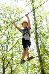 Boy on a high rope course in forest - MGIF00921