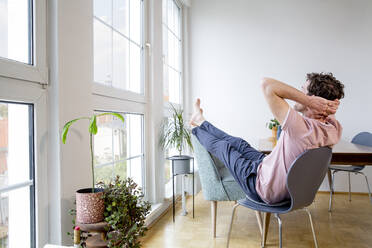 Mann sitzt zu Hause und schaut aus dem Fenster - FKF03732